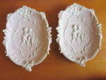 Adorable Cupid Bisque Wall Plaques Pink with White Cupids and Trim, set of two 1950s. Almost Black cherry color or light lavendar. These are marked with blue crossed arrows and have lost their sticker...