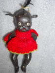 Bisque doll is a sweet African american girl with tufts of hair. She is 4 1/2 inches tall, jointed and marked Japan. She is dressed in a crocheted red dress with matching pants. She does have some loo...