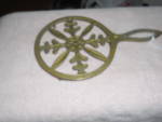 Brass trivet with the handle marked Japan. It has the lovely center pattern and sits on little feet. It is 1/4 inch high, 7 1/4 inches long and 4 1/4 inches wide. Wonderful condition.