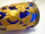 Cobalt blue glass covered in a pretty brass colored metal with a wonderful flower design. It is in nice condition and a great size for wine or cordial. It is 3 inches high and 1 3/4 inches wide. A nic...