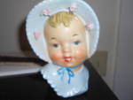 Baby head vase with wonderful detail. She is dressed in her light blue cap and matching blue dress with white lace and delicate roses around the brim of her hat. She is not marked and my best guess sh...