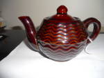 Teapot marked Japan in redware with a pretty, wavy line design. It is a single serve pot and very pretty. It is in wonderful condition and is 3 1/2 inches high and 5 3/4 inches wide. Just as found.