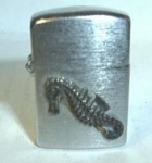 MINI SEAHORSE EMBLEM. JAPAN. 1 3/8 INCHES TALL. NICE SPARK. RESIDUE FROM OLD GLUE ON FRONT SEE PIC. TINY DINGS ON LID. ADD $4.00 FOR SHIPPING IN THE U.S.A.