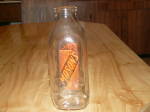 Very nice vintage collectible quart size glass milk bottle.  Clear glass in square shape with orange lettering and graphic triangular line design on two opposing sizes with other two sides clear glass...