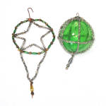 Two circa 1920s beaded glass ornaments in green, silver, and gold. The caged ball is from Japan, 2-1/4 inches diameter with a 1 inch silver beaded dangle. The unsilvered green center ornament is an ea...
