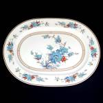 13 by 9-3/4 inch oval serving platter in the 1978 to 1983 Bleufleur dinnerware pattern by Noritake. The design features delicate Asian style flowers and flowering branches in shades of blue and rust-r...