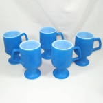 A set of five retro 1960s milk white oven glass pedestal mugs with fired-on matte blue color. I've seen other sellers attribute them to just about every Mid Century kitchen glass maker but they aren't...