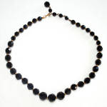 An elegant 1950s Marvella elegant basic black choker length necklace. It's 16 inches long with faceted shiny black crystal beads in graduated sizes, separated by tiny goldtone metal spacer beads. The ...