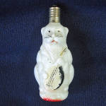 This 3 inch vintage C6 type Japan milk glass Christmas tree figural light bulb is a cat or lion wearing a morning coat and playing the mandolin. It doesn't light but easily converts to a tree ornament...