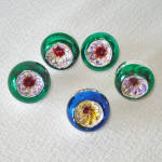 These five small indented silvered glass Christmas ornaments were made in Japan in the early 1950s. Just 1 inch diameter, one has a blue rim opening with red and yellow tinted center. The others have ...