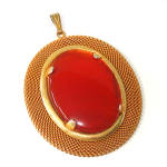 This unsigned Mid Century pendant necklace features a carnelian or orange agate stone cabochon framed in a retro gold tone chain mesh frame. Overall size is 2-3/8 by 2-1/8 inches. The mesh has a coupl...