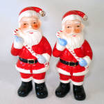 A pair of virtually identical full figure Santa Claus ceramic figures from Mid Century Japan. They're about 4-1/2 inches high, each holding a candy cane. There's a tiny bit of wear to the red paint on...