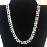 This lovely vintage Coro necklace has alternating faux pearls and aurora borealis rhinestones below finely ribbed silvertone chevron links. The rhinestones were picking up and reflecting blue on the d...
