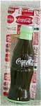 Classic Coca Cola bottle Ceramic Figurine made by Enesco from 1993-1994. It is approximately 5 inches tall. The figure represents classic Coca Cola bottles. It is brown with a white logo, and it is gr...
