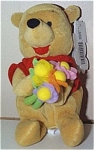 The Disney Flower Pooh bear mini-bean bag plush, is holding a colorful bouquet of cloth flowers and was intended for Mother's Day when he was produced in about 1997. He is dressed in his red 'Pooh' sh...
