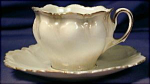 Porcelain. Germany. Unmarked, attributed to R.S. Prussia.  c. 1900s.  High luster white body with pale green at the top & bottom of the cup. Gilt edged & sponged gilt, gilt ring around saucer well and...