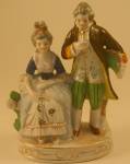 Colonial couple, with the lady seated and the man standing. Pretty good sized: 4 1/2 inches wide and not quite 7 inches high. Stamped "Hand Painted Made in Occupied Japan." Excellent conditi...