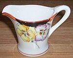 This is a true piece of art deco pottery. The rather flared look to the creamer as well as the<BR>understated trim work add to the charm of the two pansies hand painted on the front. Simply<BR>marked ...