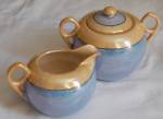 Lovely old 50s cream and sugar set in the blue and peach luster. Both marked simply Made in Japan in black. Both in excellent condition. Sugar stands 4" tall, with lid, by 5 5/8" across the...