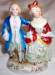 Lovely old porcelain figurine made in occupied Japan. Man and woman in period dress stroll arm and arm. Nice bright colors. Excellent condition. Stands 4 7/8" tall.