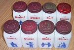 Featured for your enjoyment is a set of 8 old spice shakers done in milk glass. These all have a<BR>Dutch theme to the blue pattern on front. All have their original red tin lid although some lids<BR>...