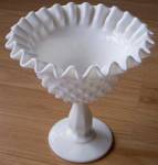Double crimped rim on this old piece of Fenton Art Glass. Done in milk white and the hobnail pattern. Excellent condition. Stands 5 1/2" tall by 8" wide.