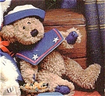 is an 8.5 inch medium brown colored chenille bear with navy felt paw pads with black stitching and black beaded eyes.  This dressed teddy bear wears a removable navy blue sailor collar with two white ...