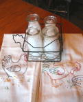 Four cool half pint vintage glass milk bottles and chicken wire basket with chicken motif. First is a Twin Pines bottle, nice condition. Next is a 5 cent Universal Store Bottle, (some age/wear, but ne...