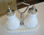 Vintage Imperial milk glass shakers with stand. The shakers have the raised IG mark on bottoms which dates them to: 1951-1972. They are fat, good sized shakers with chrome lids and stand 4.5 inches ta...