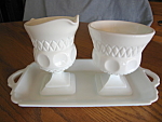 Milk glass creamer, sugar and tray. Not sure who made it; has 4 mold lines in the creamer & sugar, and the pattern looks like diamonds and dots. Creamer is 4.75 tall; sugar is 4 inches tall; tray is 1...