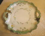 Antique decorated milk glass cake tray. The colors are green, yellow and gold against the white milk glass. Very heavy tray and it is translucent when you look at it up at a light which antique milk g...