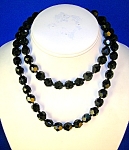 Vintage 31 inch necklace of black faceted Jet/Glass beads, with individual tiny glass bead spacers.  There is a round faceted glass jewel on the push  clasp, and on the side of this it has Japan. The ...