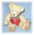 16 Inch curly hair bear wearing a red silky vest with Selfridges embroidered on his vest. He is very soft and cuddly, and his legs are jointed. He is in lovely condition, and is not pellet filled. (Se...