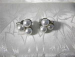 Vintaged Silvertone clip earrings with three large 8mm faux pearls in each earring. The back of the clip is marked Japan.  It appears that one of the pearls is smaller and may have been replaced (pric...