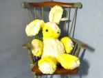 an adorable old yellow and white plush rabbitt, that is wind up and play's a lullably. He has his original "Character' tag, and his little eyes are glass. He is in wonderful condition