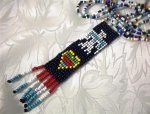 a double row of multi colored Native American beads with beaded thunderbird pendant 48 inches pendant 4 1/8 and 7/8 wide 