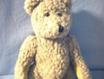 a small jointed Boyds Teddy Bear, with velvet paws, and handstitched mouth. His label is still there, but needs a stitch to secure. He is 8 1/2 inches tall.