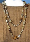 Lovely Vintage  48 inch necklace of Glass beads. The largest bead is 1 inch, and they are in shades of amber /grey/clear and gold. Some of the beads are large glass hearts.        