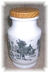 This vintage milk glass jar with metal lid measures 4 1/2 inches tall by 2 3/4 inches wide.  It has a W or M mark on the bottom with the number 8.  The scene around the piece is of the victorian age w...