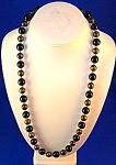Vintage Black and Gold Necklace . Each of the beads is 11.7 mm. They are 24 inches long, and they have tiny gold spacers in between the beads.