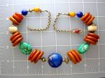 Beautiful and Different Necklace of Flat Coppel Amber beads mixed with Chinese Turquoise, Silver cklad Shells and a large center 1 inch Lapis bead. There are Silver spacers in between, and a Silver S ...
