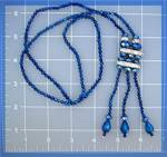 <BR><BR>Necklace of Vibrant Faceted Blue Crystals with White Crystal Accents. The Necklace is 29 Inches with a 4 inch Tassle with Teardrop Crystals on the 3 drops.<BR><BR><BR>