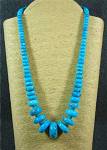 Navajo Strung Nocozari (Mexico/Arizona) Turquoise Necklace Sterling Silver Points and Hook Clasp 258 Grams 22 Inches 1 1/4 Inch Center Bead - 7mm Smallest. Brightest Blue Color with Dark Matrix.