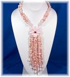 22 Inch 4 Strand necklace of Hand knotted Angelskin Coral Nuggets with Rose Quartz Spacers 2 Inch Angelskin Coral Flower 5 inch Tassel 12 Strands of Angelskin Coral Round Toggle clasp.