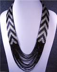 Black and Silver Beaded Necklace no clasp goes over the head. The Necklace is 31 inches around the neck the beads have a cloth back and the lower part does not have cloth back the beads drape.