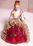 Very pretty and detailed colonial lady with real lace for the front of her skirt.  The stiffened red net is trimmed with lace border which is all intact.  The rest of her skirt is hand painted with ti...