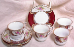 Very pretty set of 4 demitasse cups and saucers in a WILD ROSE type of pattern with brick red background and gold rims.  Stamped with the GOLDCASTLE made in Japan mark on the bottom of each piece, dat...