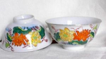 Very nice pair of rice bowls hand painted with bright orange and yellow flowers on the front and a budding orange flower on the back.  The porcelains measure 4 1/2