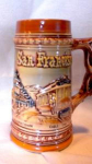 Colorful stein featuring popular San Francisco motifs including a cable car, Chinatown, the Golden Gate Bridge and the city sky-line.  The stein is marked 