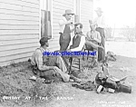 Matted and ready to pop into a standard frame: This interesting 8" x 10" photo print is from an original photo marked 1908 and depicts 5 cowboys with two receiving haircuts with a saddle sit...